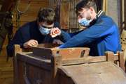 Pascal Querner und ein Kursteilnehmer untersuchen ein Exponat aus Holz im Waldbauernmuseum Gutenstein