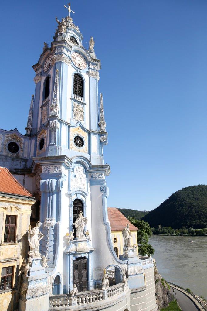 Der blaue Kirchturm des Stifts Dürnstein mit Donau im Hintergrund